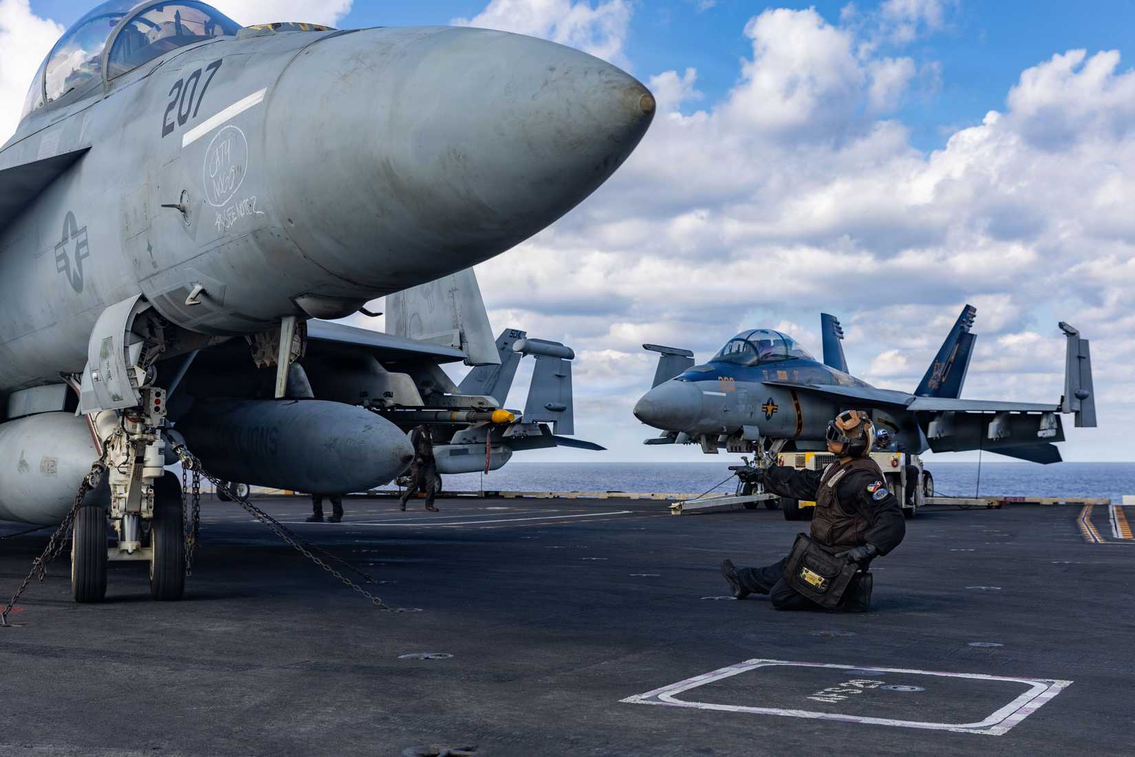 A Sailor signals to an FA-18F Super Hornet aircraft, attached to Strike Fighter Squadron 213, on the flight deck of the world’s largest aircraft carrier, USS Gerald R. Ford (CVN 78).