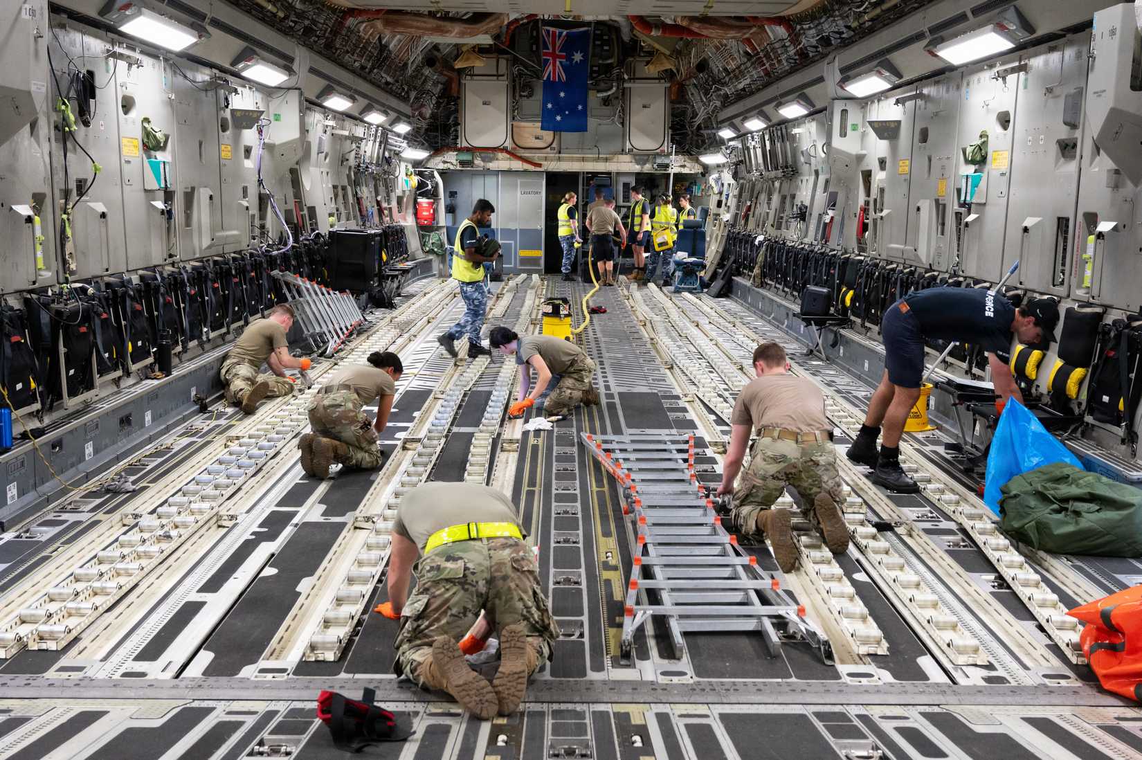Air Force Airmen assigned to the 911th Maintenance Group and Royal Australian Air Force Airmen refurbish the floor of a C-17