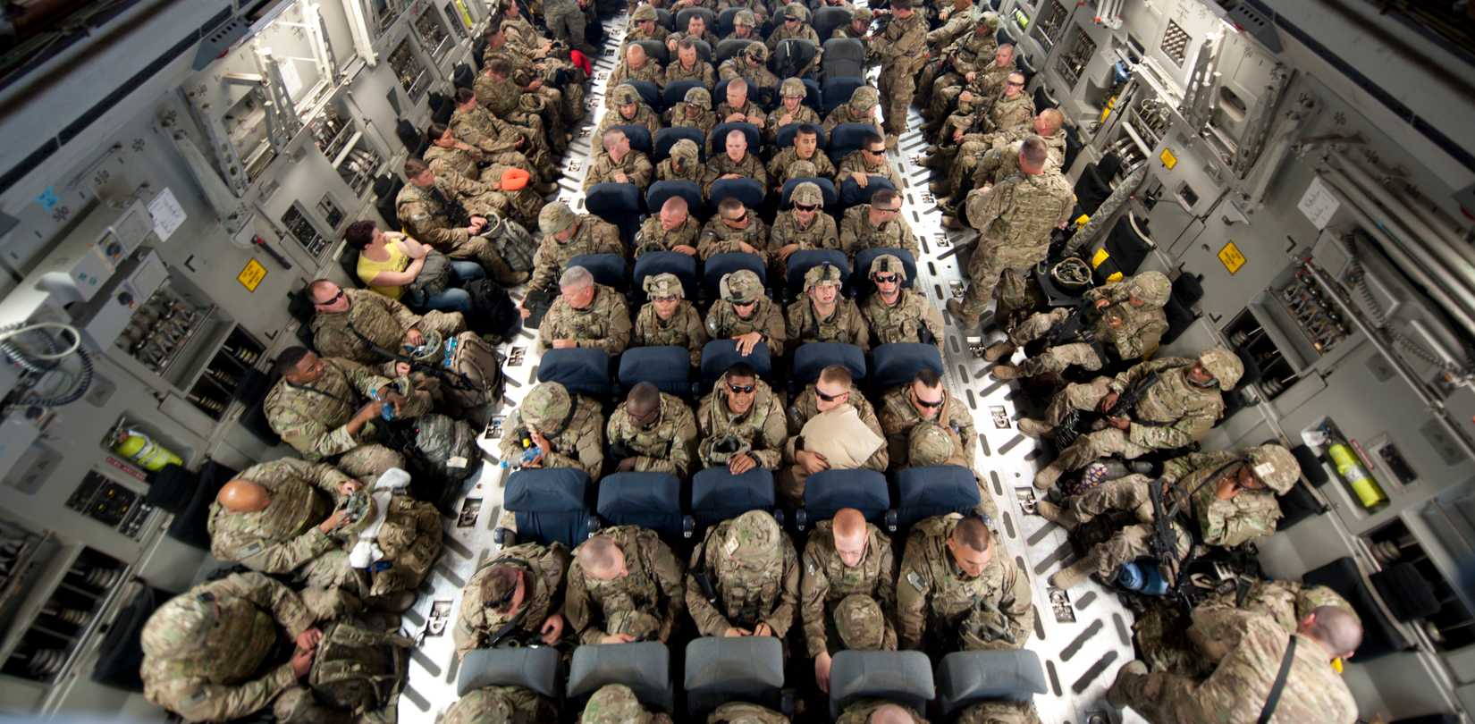 Air Force and Army service members secure seats on a C-17.