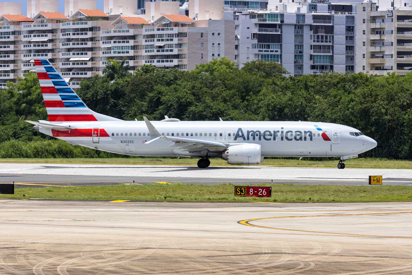 American Airlines Boeing 737 taxiing on the ground with lots of trees in the background
