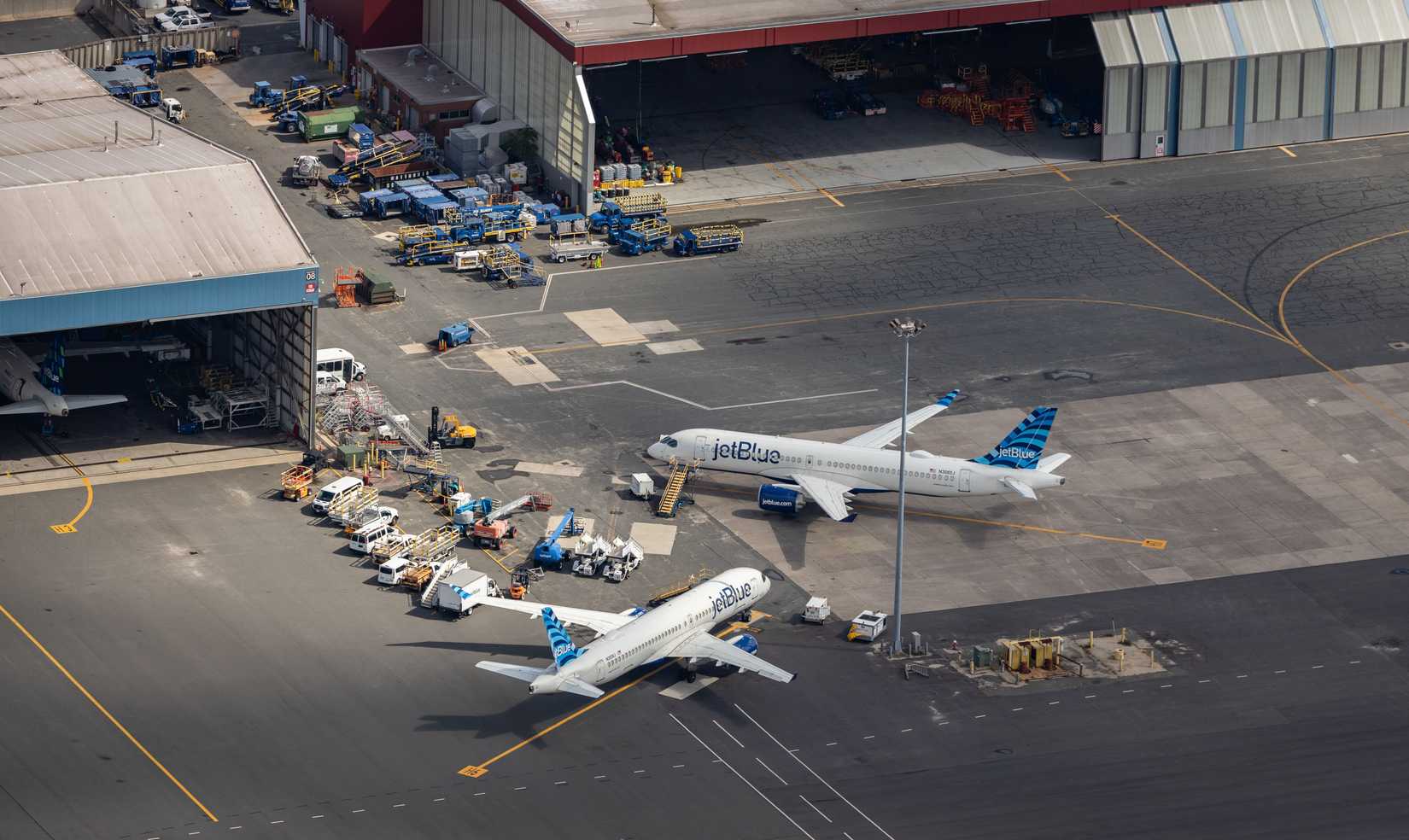 An aerial photograph of a pair of JetBlue Airways planes parked near hangars in Boston.