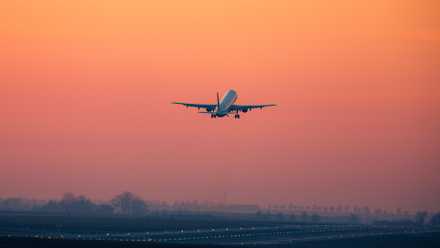 An aircraft takes off during sunset