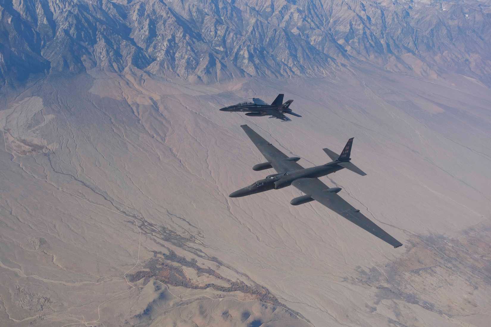 An FA-18F Super Hornet of Air Test and Evaluation Squadron Nine (VX-9), and a U-2 Dragonlady fly over Naval Air Weapons Station China Lake.