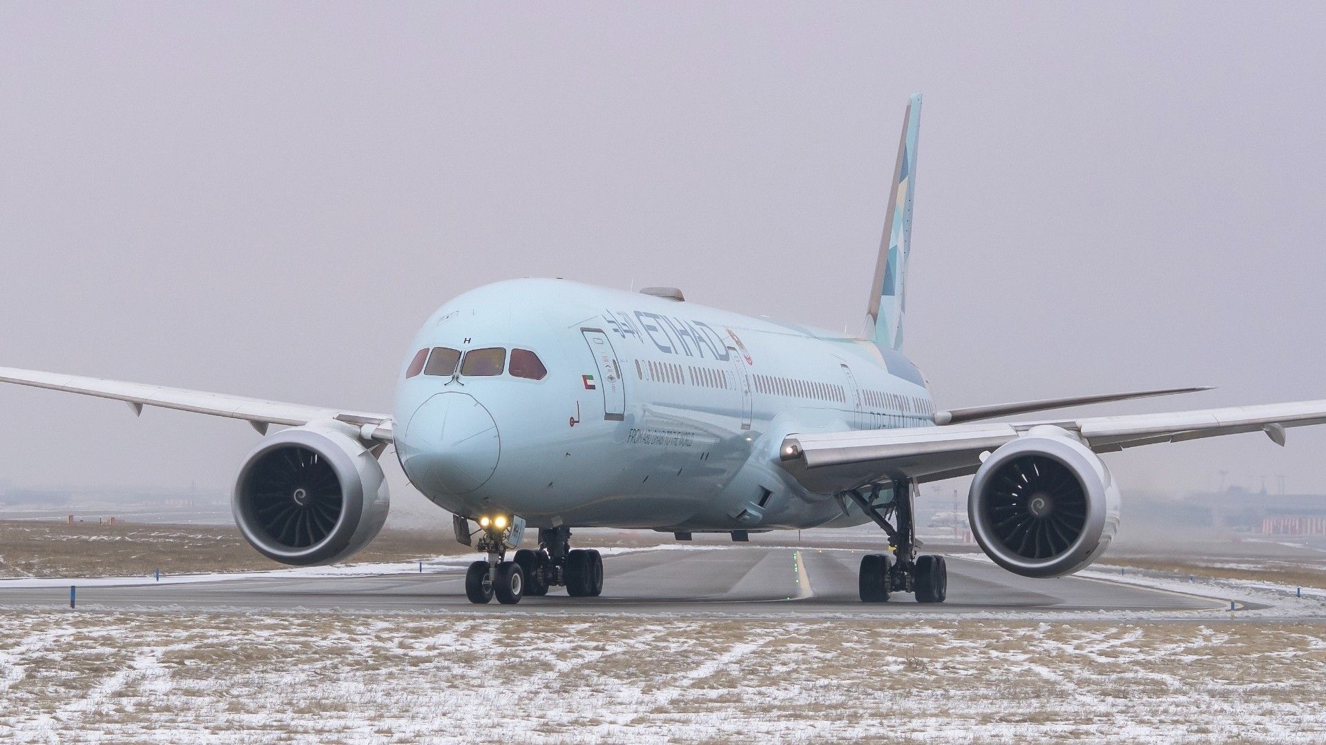 Etihad Airways Boeing 787 Dreamliner with special livery taxiing on snowy runway.