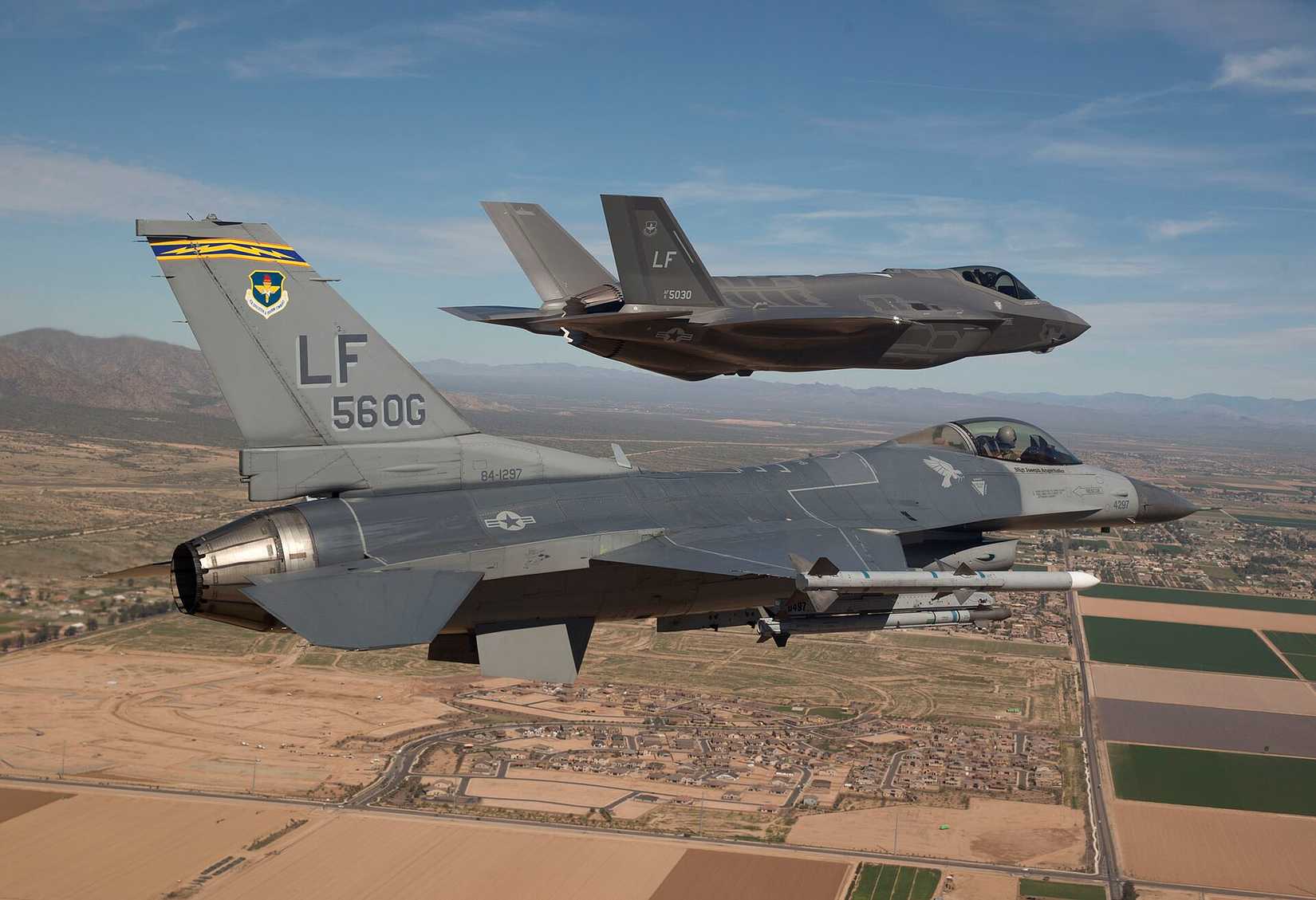 Maj. Justin Robinson flies the 56th Operations Group flagship F-16 Fighting Falcon March 10, 2014, as he escorts the first F-35 Lightning II to its new home at Luke Air Force Base, Ariz. 