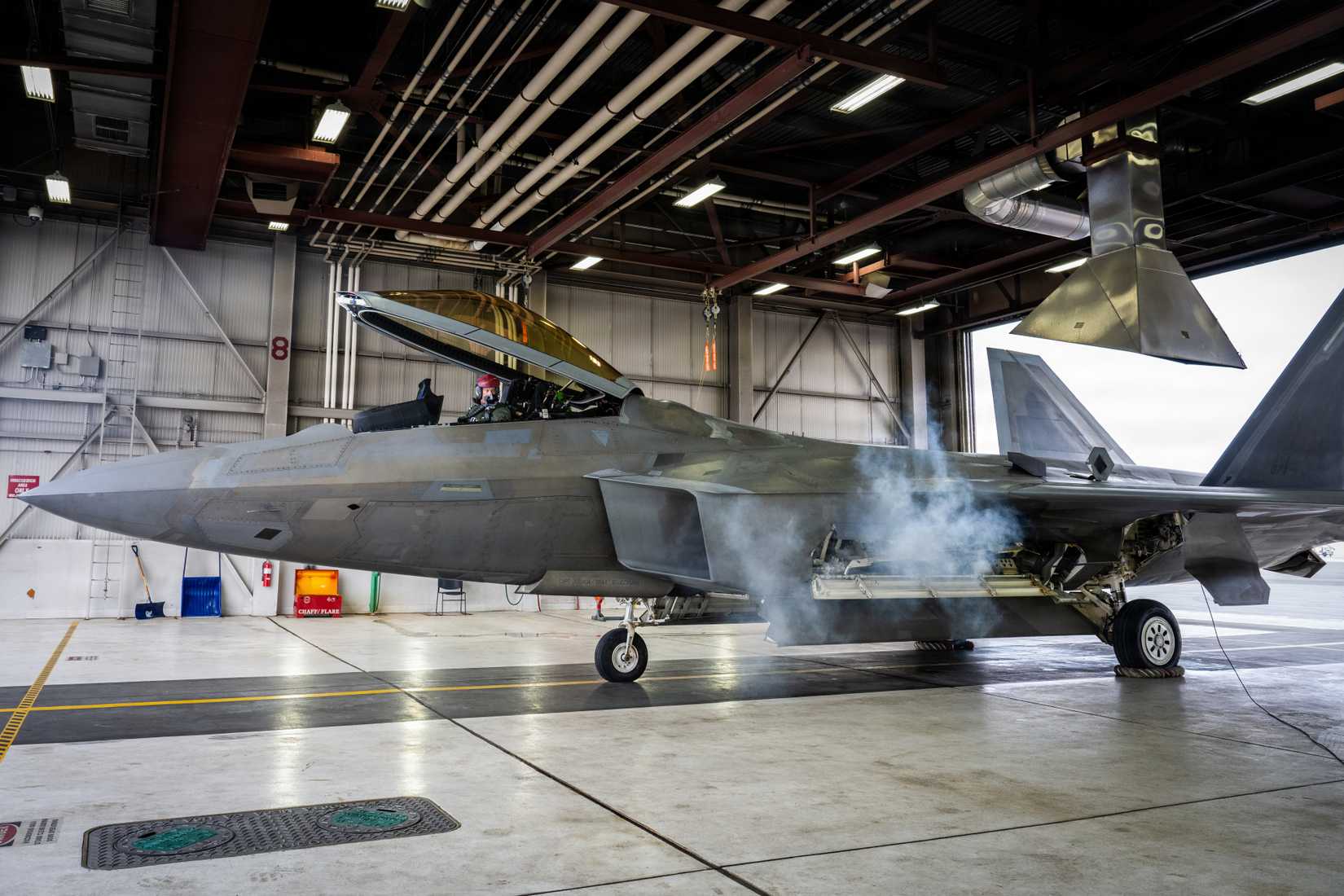 ir Force Col. Brian Budde, 477th Fighter Group commander, starts the engine of an F-22 Raptor.