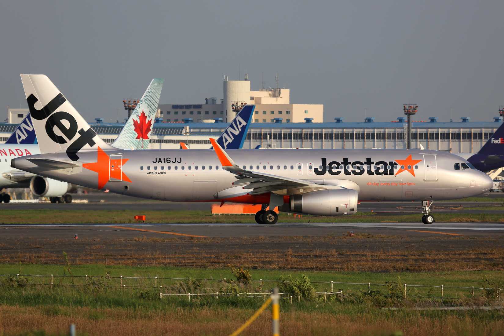 Jetstar A320 taxiing with ANA and Air Canada aircraft in the background