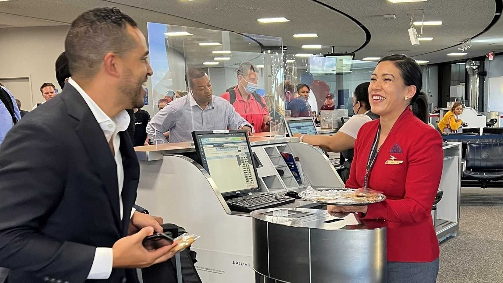 delta red coat serving a customer at check-in