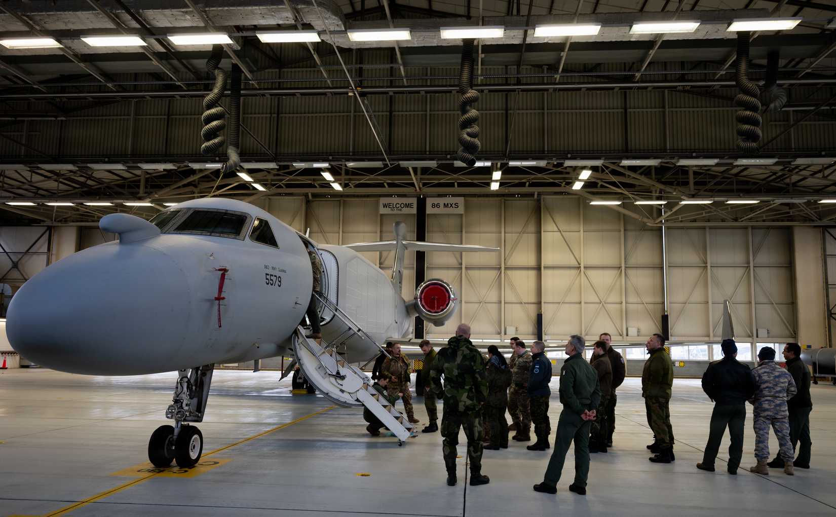 Military personnel assigned to Ramstein Air Base, Germany, receive a tour of an EA-37B Compass Call aircraft assigned to the 55th Electronic Combat Group.