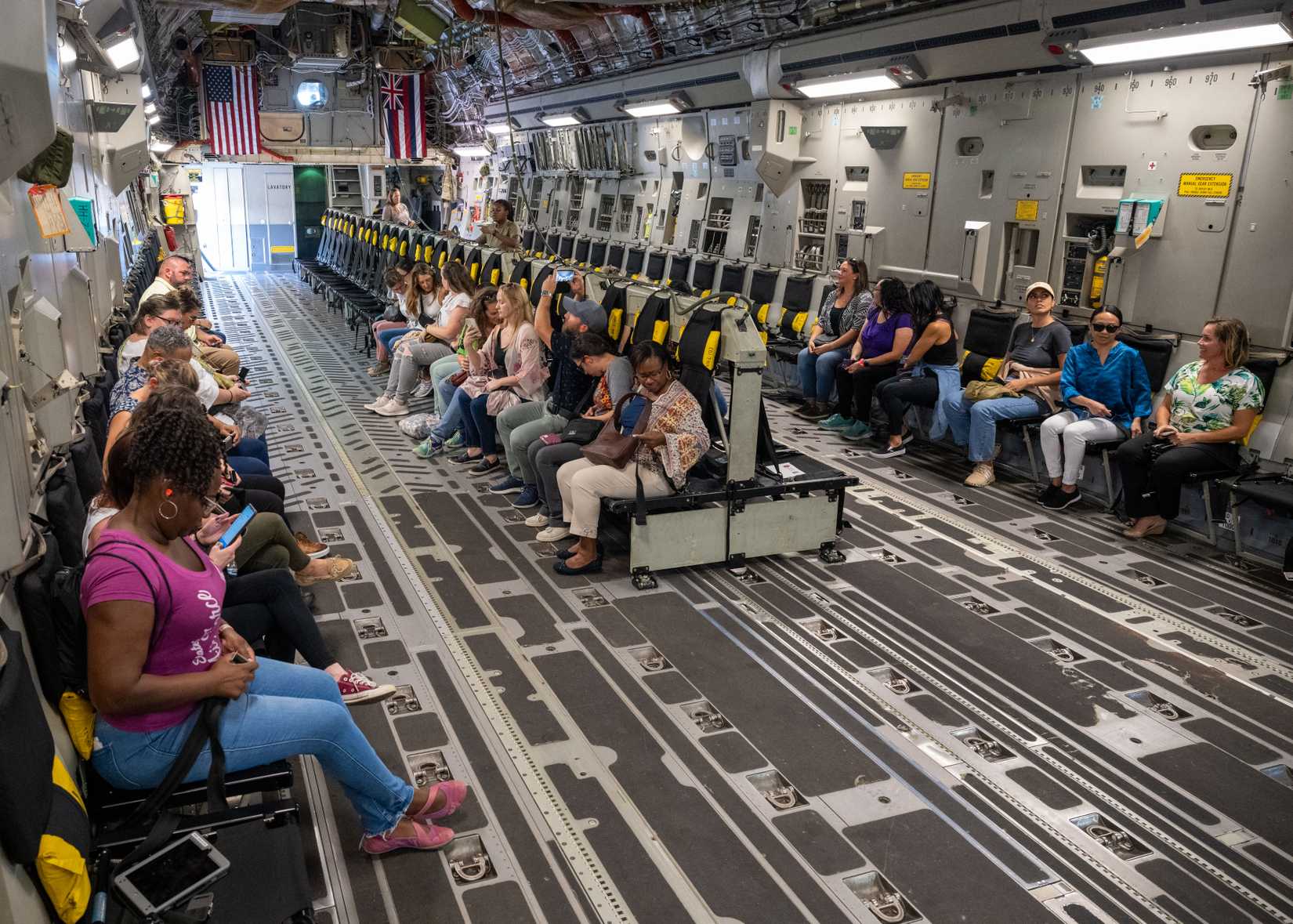 Military spouses take their seats on a C-17 Globemaster III for a flight.
