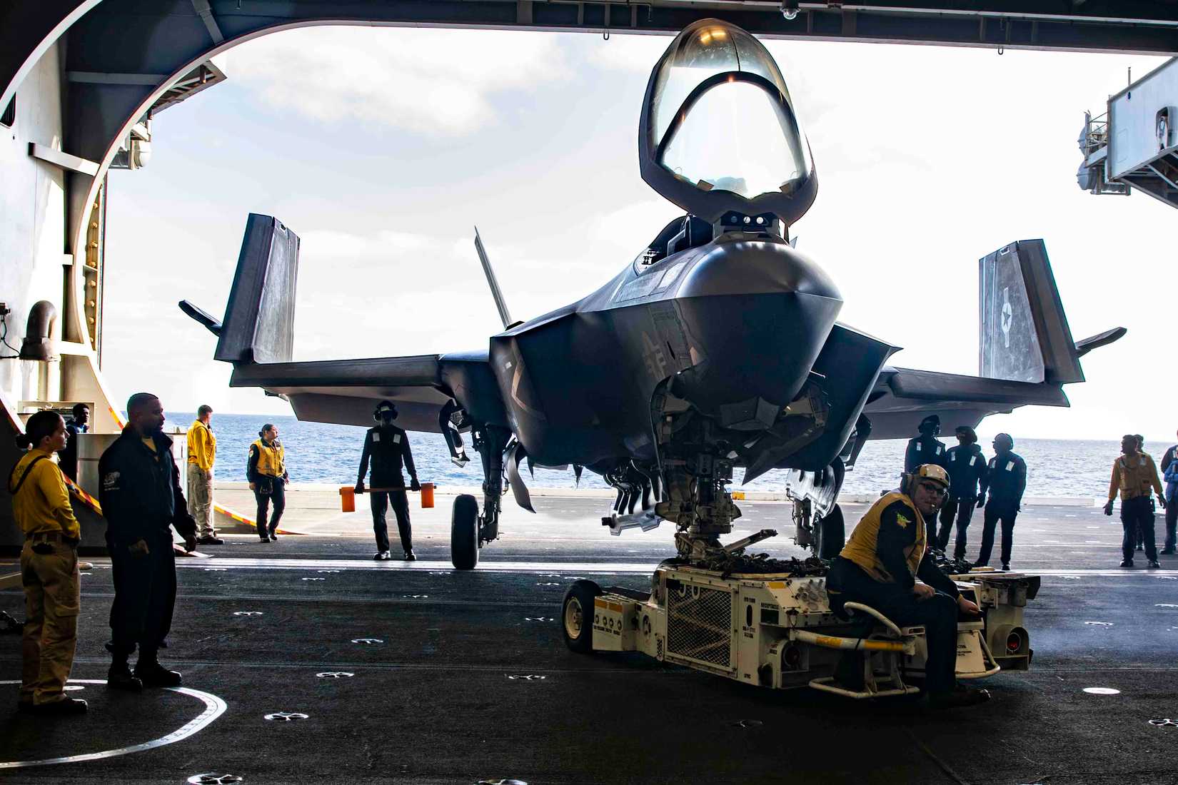 Navy Sailors direct a F-35C Lightning II, attached to Marine Fighter Attack Squadron (VMFA) 314, into the hangar bay of Nimitz-class aircraft carrier USS Abraham Lincoln (CVN 72).