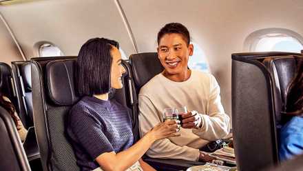 Passengers Dining In A Qantas Premium Economy Cabin