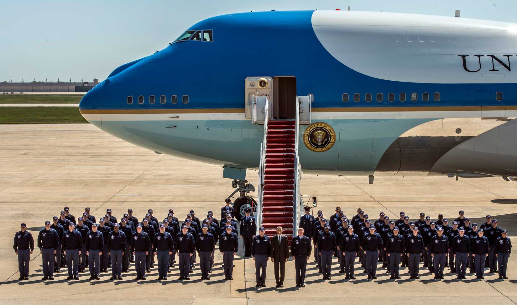 President Barack Obama and Airmen from the Presidential Logistics Squadron, pose in front of Air Force One.