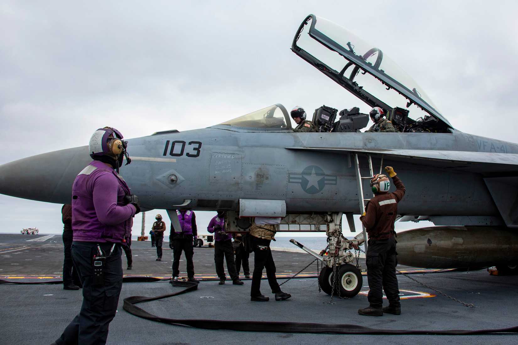 Sailors conduct pre-flight checks on an FA-18F Super Hornet, attached to Strike Fighter Squadron (VFA) 41, on the flight deck.