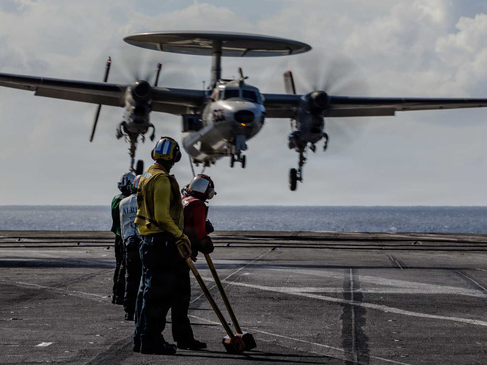 Sailors observe an E-2D Hawkeye, attached to Airborne Command and Control Squadron 124, land on the flight deck of the USS Ford (CVN-78)