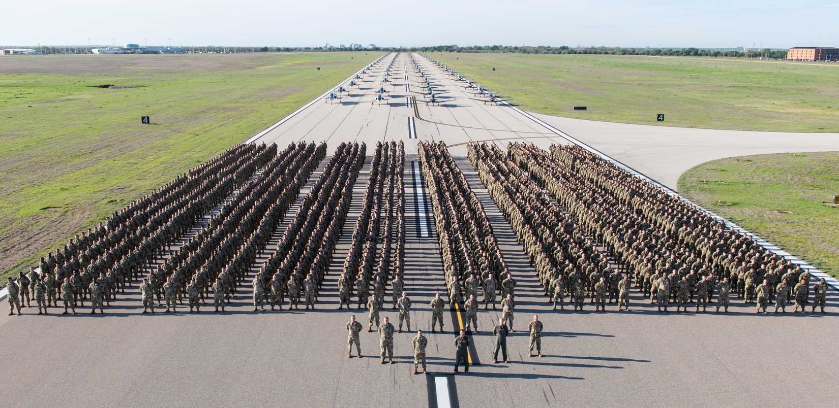 Four thousand Airmen and 80 aircraft stand in formation in a one-of-a-kind elephant walk April 7, 2023, at Sheppard Air Force Base, Texas. Technical training students from the 82nd Training Wing joined 40 T-38 Talon and 40 T-6A Texan II trainer aircraft from the 80th Flying Training Wing on a runway to shine a spotlight on the importance of training as the foundation of airpower. (U.S. Air Force photo by Alan Quevy)