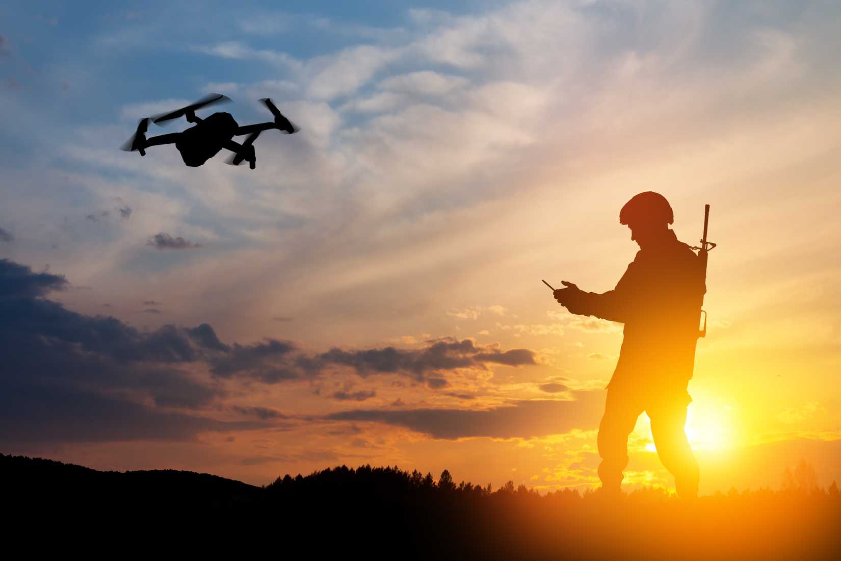 Silhouette of soldier are using drone and laptop computer for scouting during military operation.