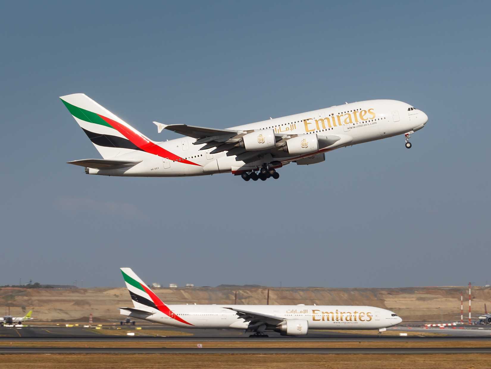  Emirates Airlines Airbus A380 departing and Emirates Boeing 777-300ER on the runway