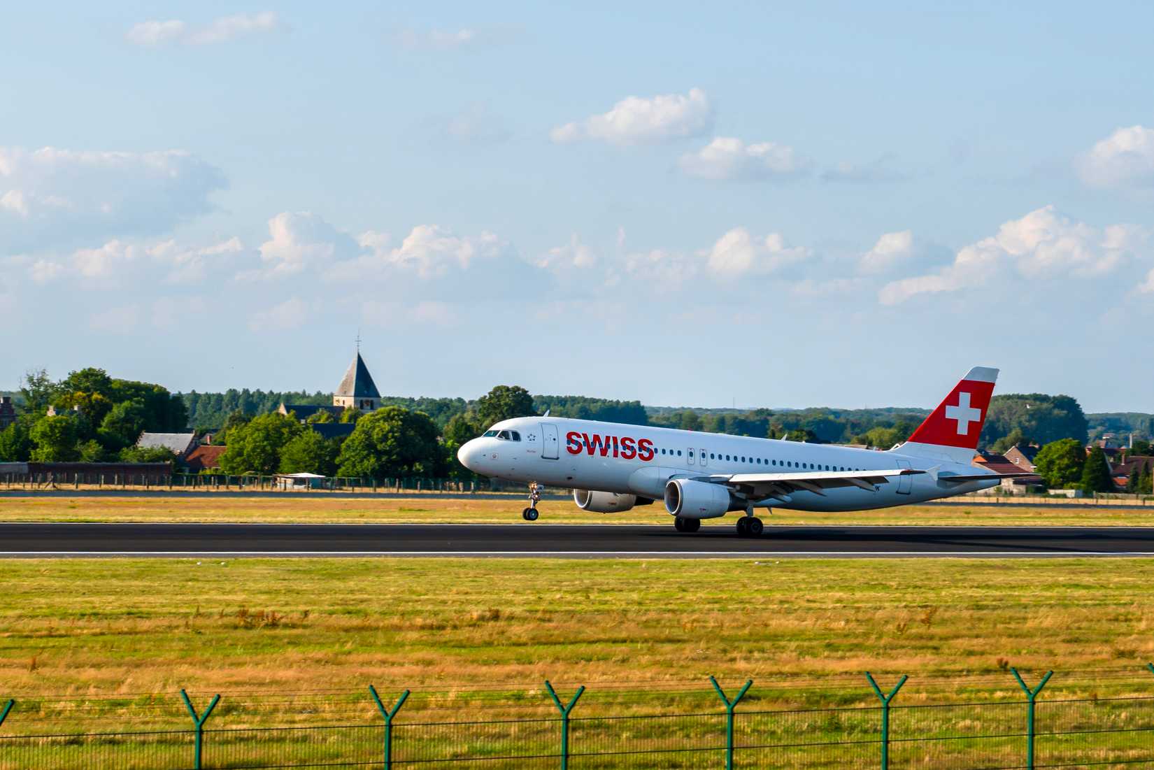 Swiss International Air Lines Airbus A320 Landing at Brussels Airport and and the front wheel is still in the air.