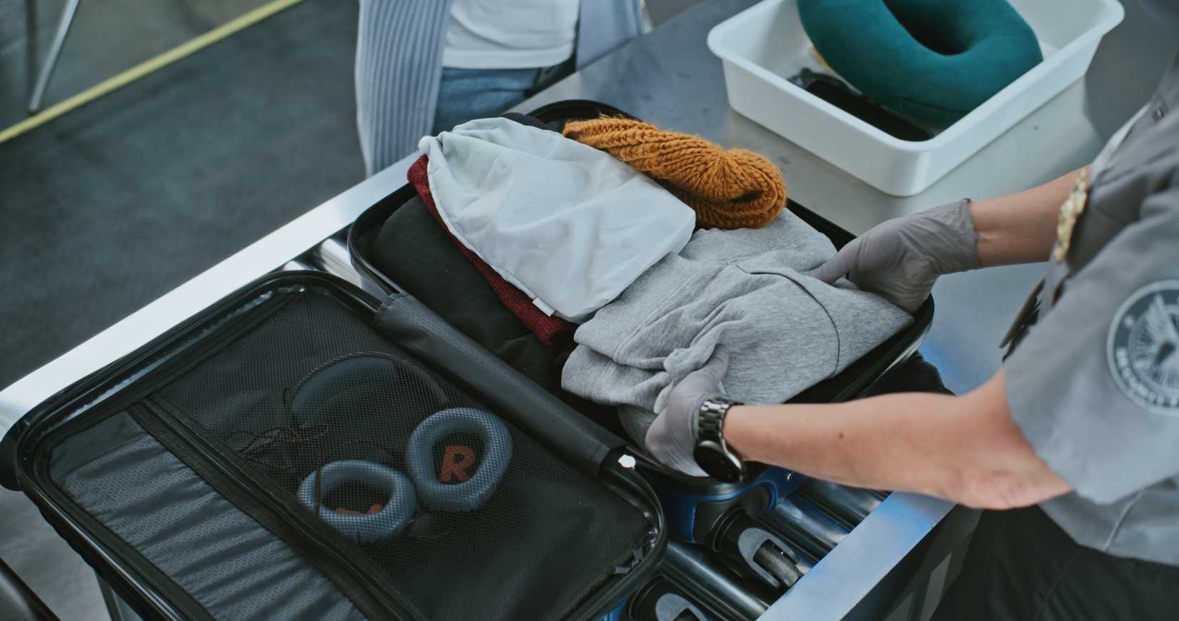 TSA checking a passengers baggage