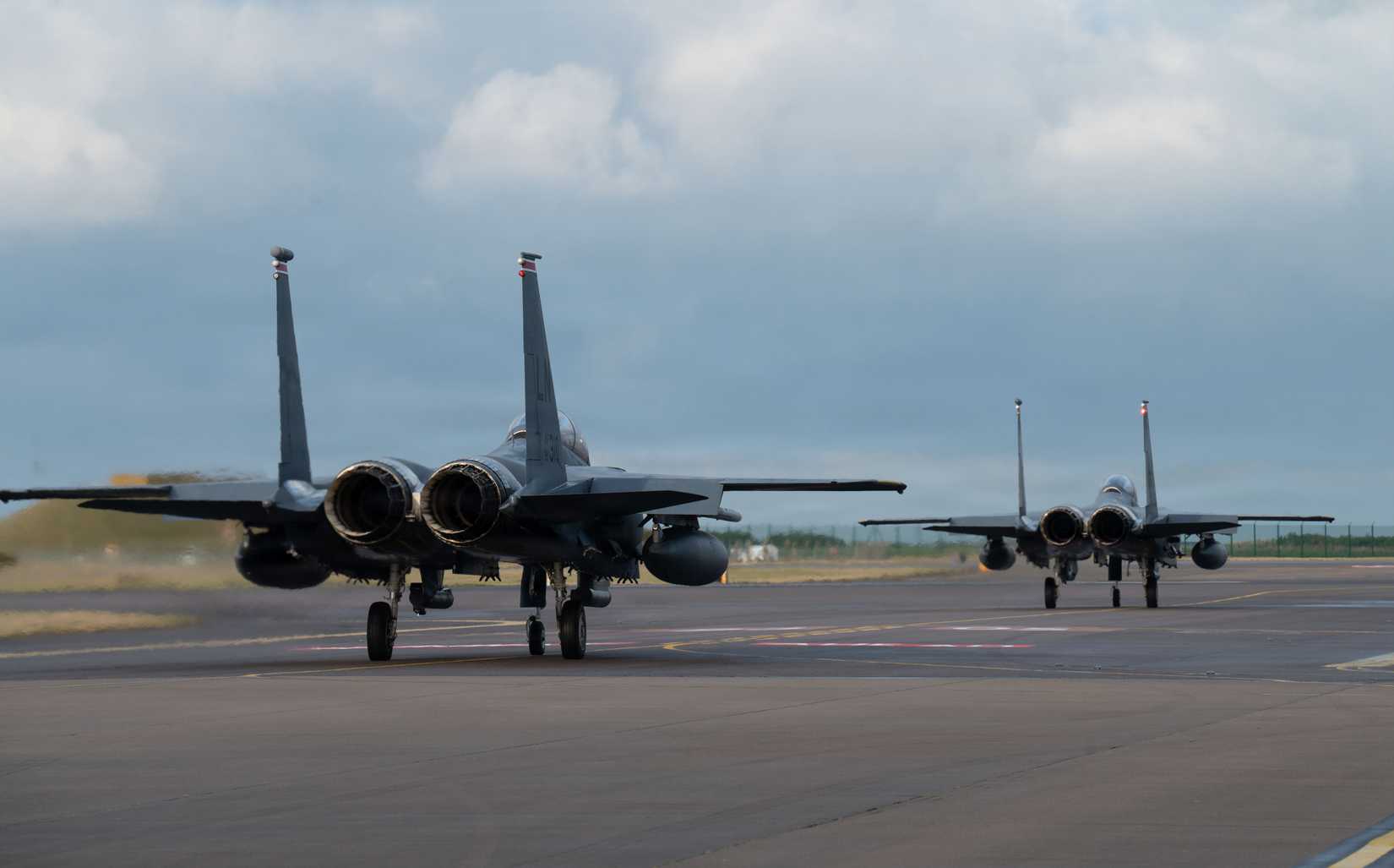 Two F-15E Strike Eagles taxi on the flightline following a hot-pit during Exercise Point Blank at RAF Lossiemouth, Scotland, Jan. 26, 2026.
