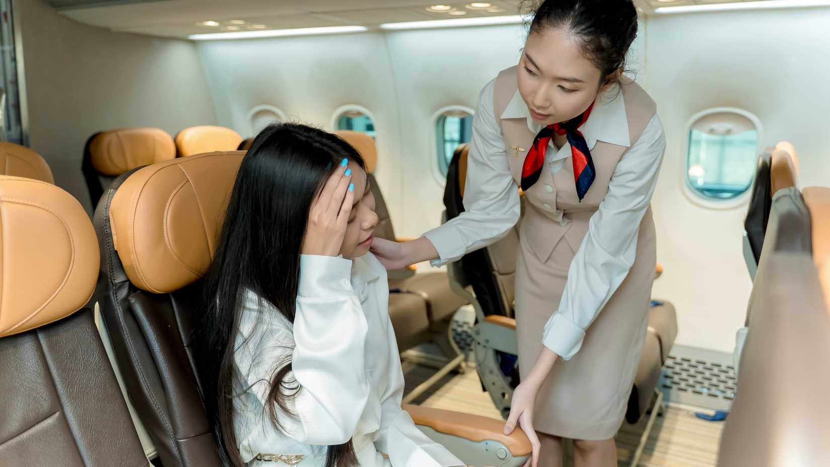 Flight attendant helping young passenger