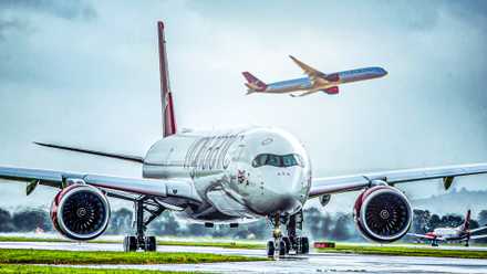 Virgin Atlantic Airbus A350 taxiing while another A350 is taking off in the background