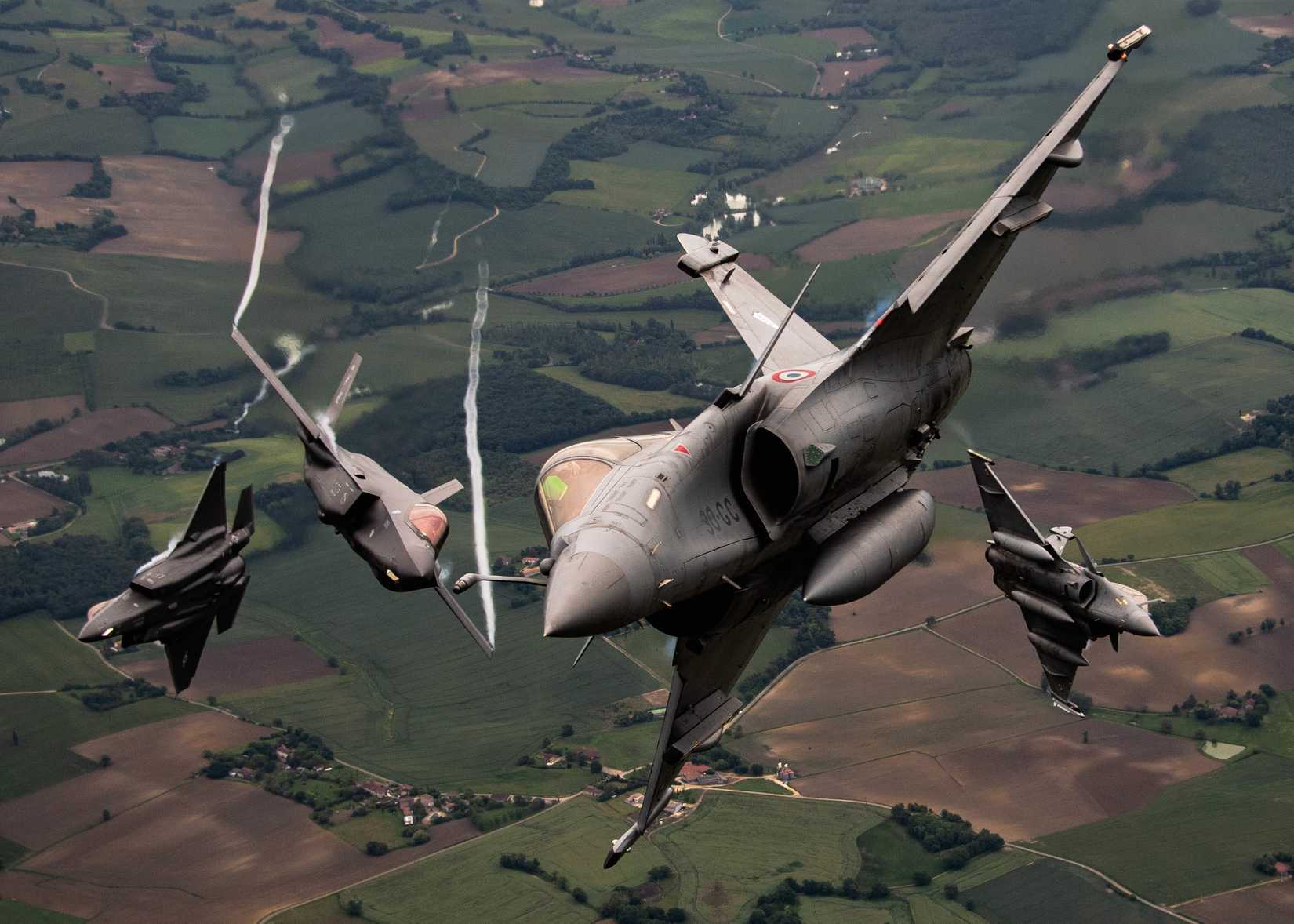 Two US Air Force F-35A Lightning IIs and two Dassault Rafales break formation during flight May 18, 2021 over France. 