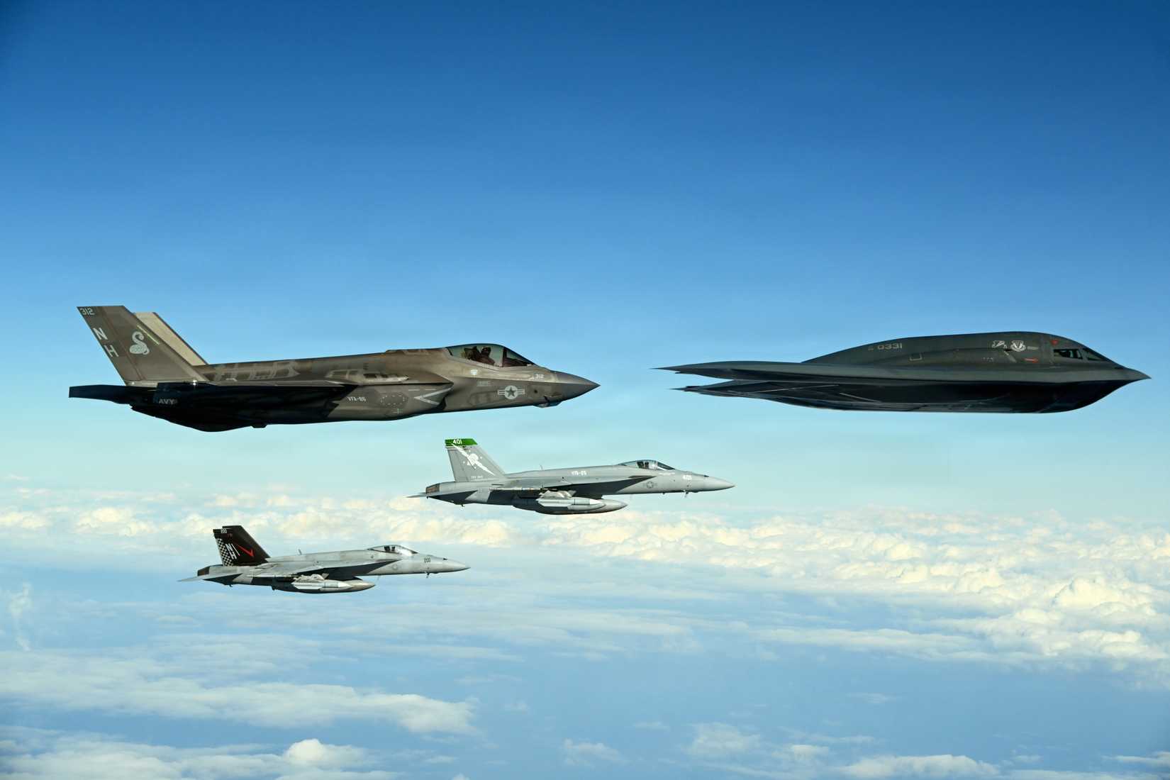 A  B-2 Spirit conducts an integrated maritime strike training exercise with Navy F-35C Lightning II and FA-18E Super Hornets.