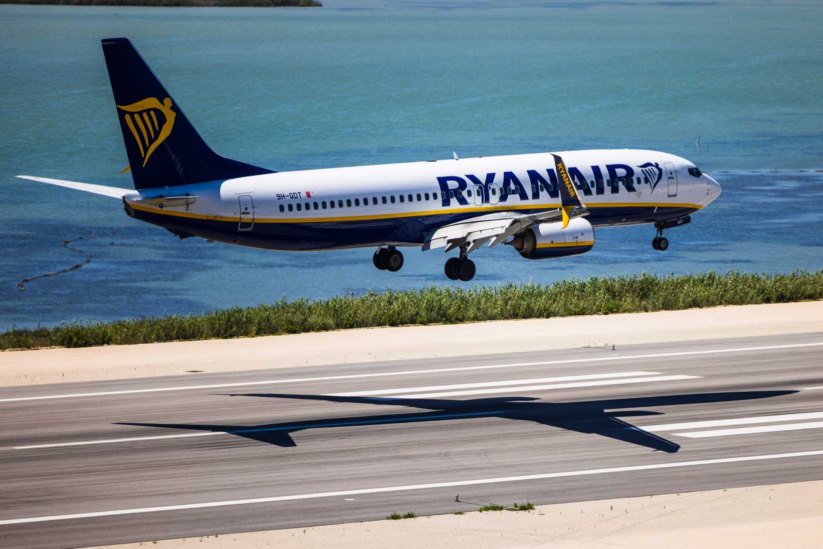 A high-angle shot of a Boeing 737-8AS (registration 9H-QDT) operated by Malta Air for Ryanair, moments before touchdown at Corfu International Airport (CFU), Greece.