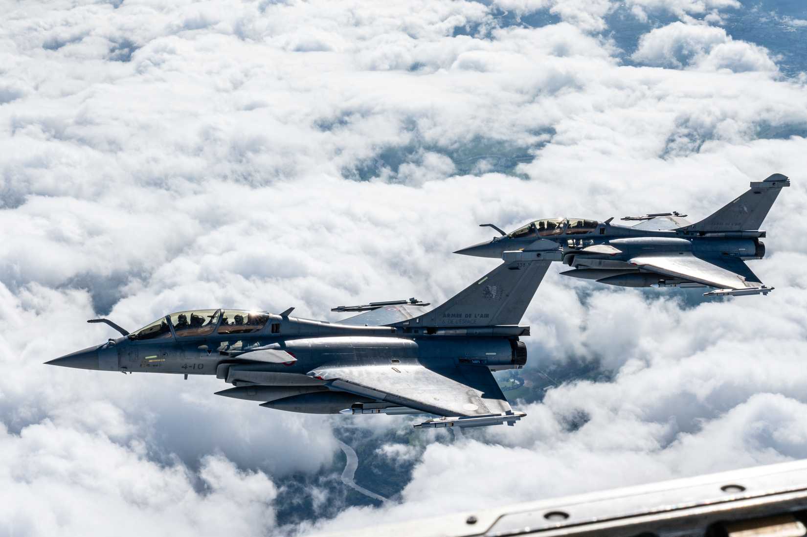 A pair of French Rafale fighter jets fly in a formation.