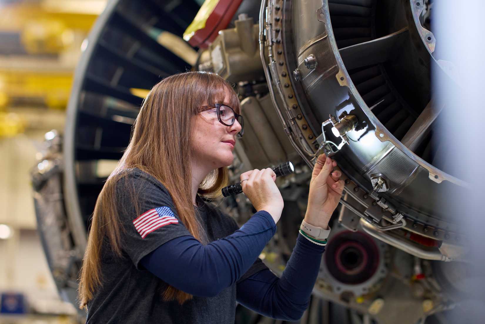 A technician at Pratt & Whitney’s West Palm Beach Engine Center performs a maintenance check on a PW1100G-JM GTF engine