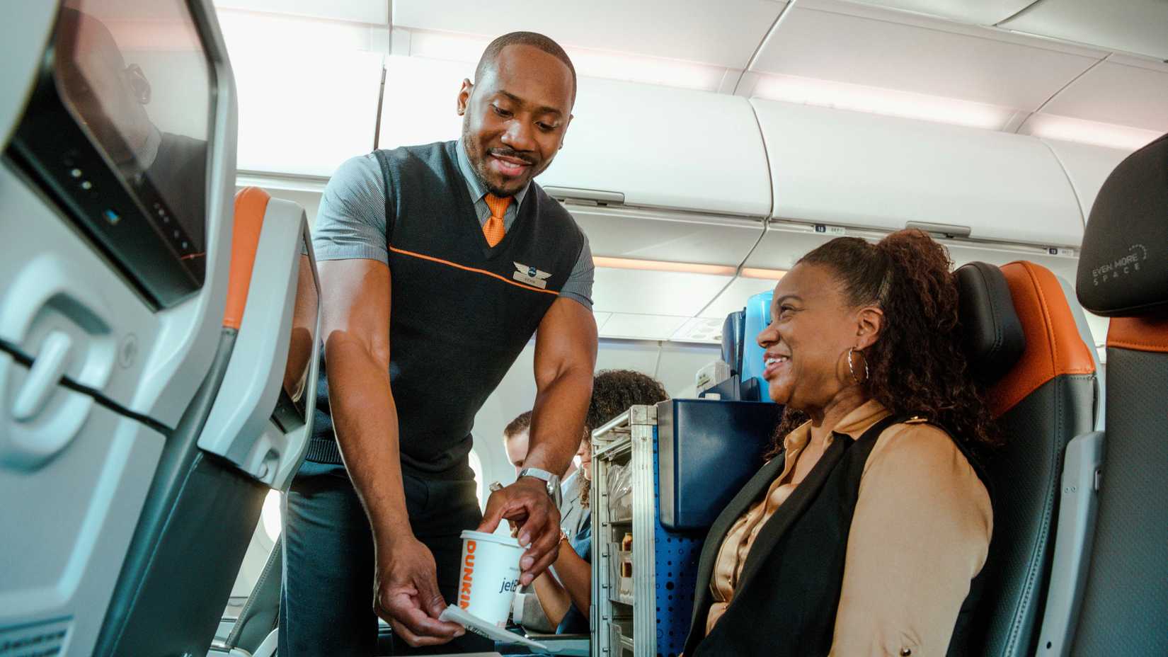 JetBlue flight attendant serving beverages