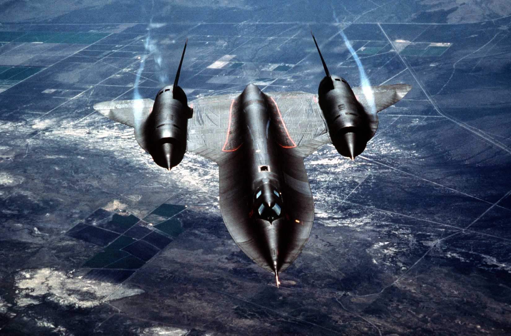 Air to air three-quarter-front view of a 9th Strategic Reconnaissance Wing SR-71 Black Bird as it approaches a tanker for refueling. Exact Date Shot Unknown