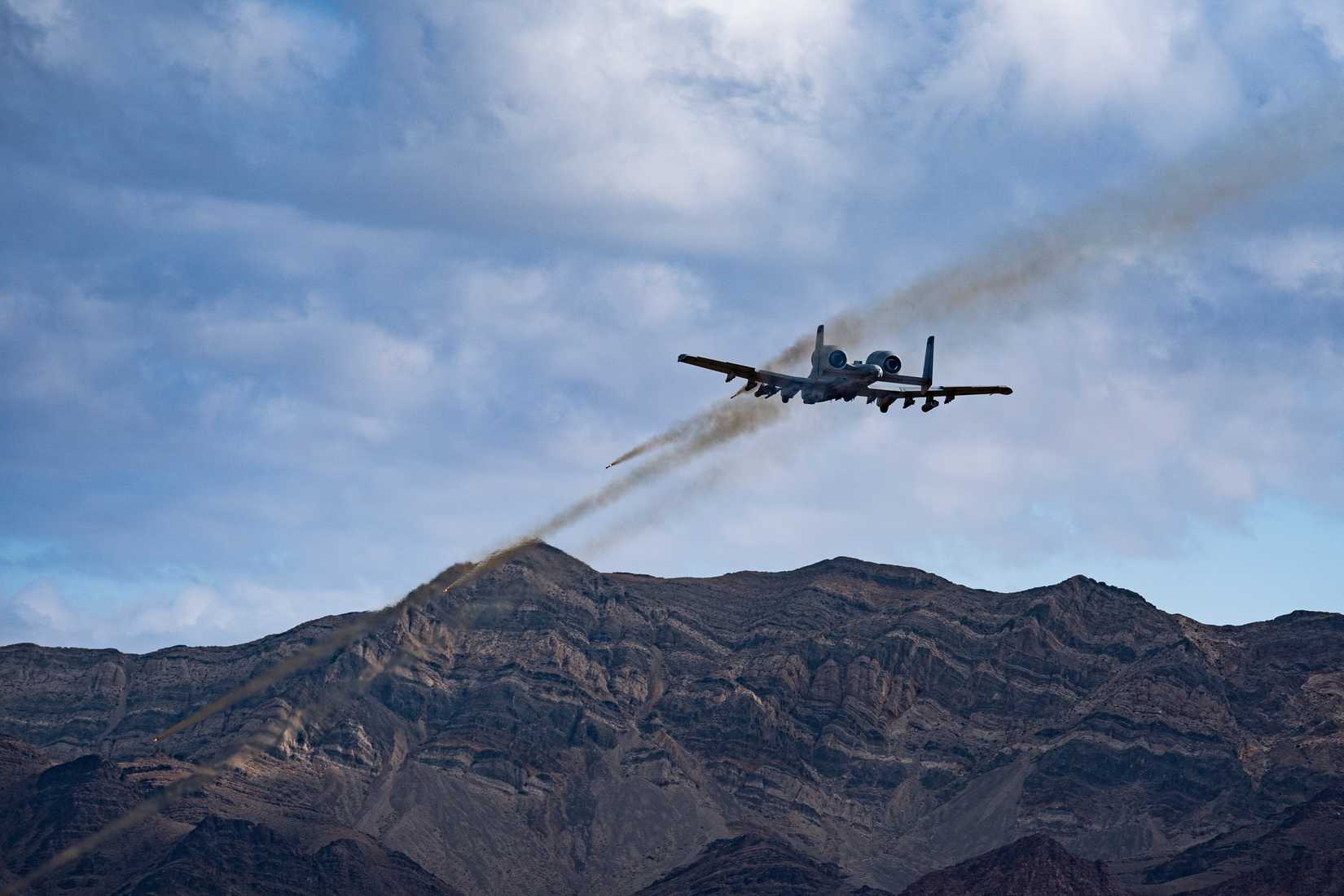 An A-10 Thunderbolt II assigned to the 422nd Test and Evaluation Squadron, fires Hydra rockets over the Nevada Test and Training Range, Nevada, Dec. 7, 2022.