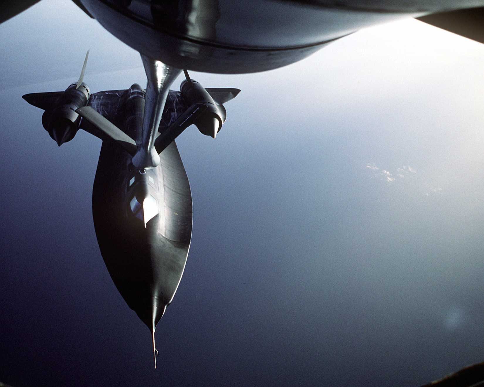 An air-to-air front view of an SR-71 Blackbird aircraft being refueled by another aircraft during refueling operations.