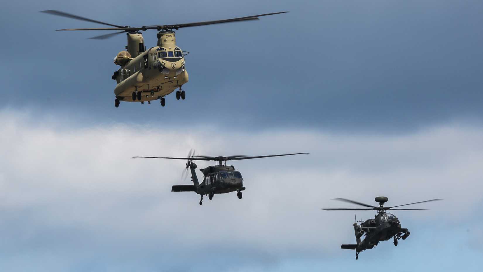 Army helicopters, assigned to the 25th Combat Aviation Brigade, fly in formation.