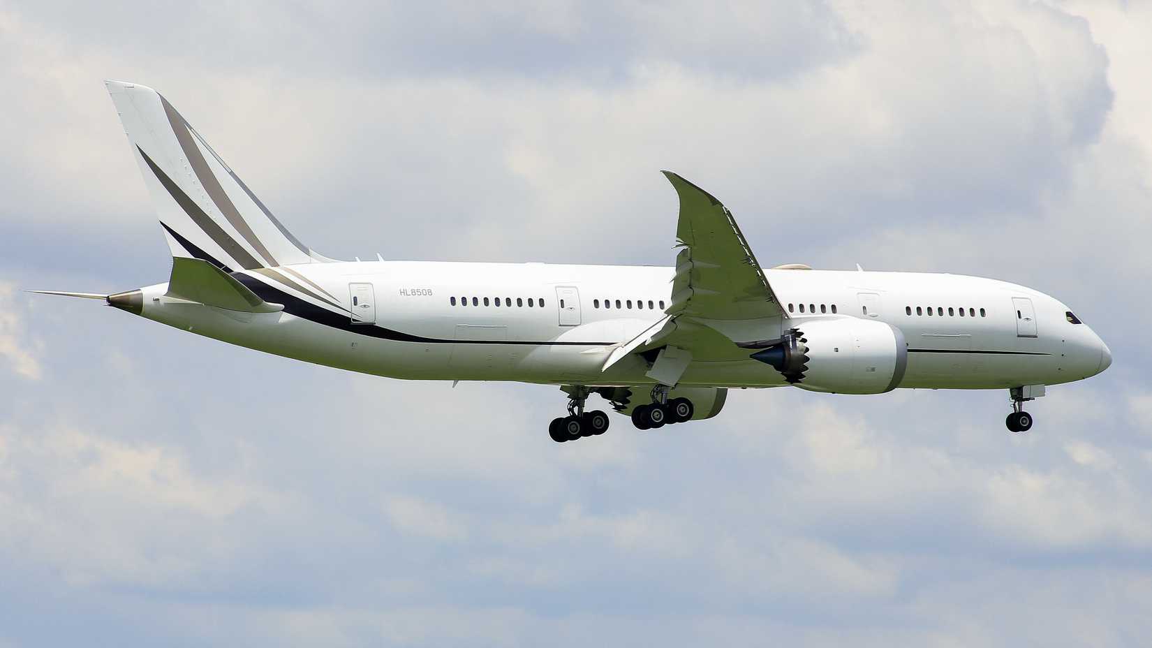 Boeing 787 BBJ flying across cloudy sky