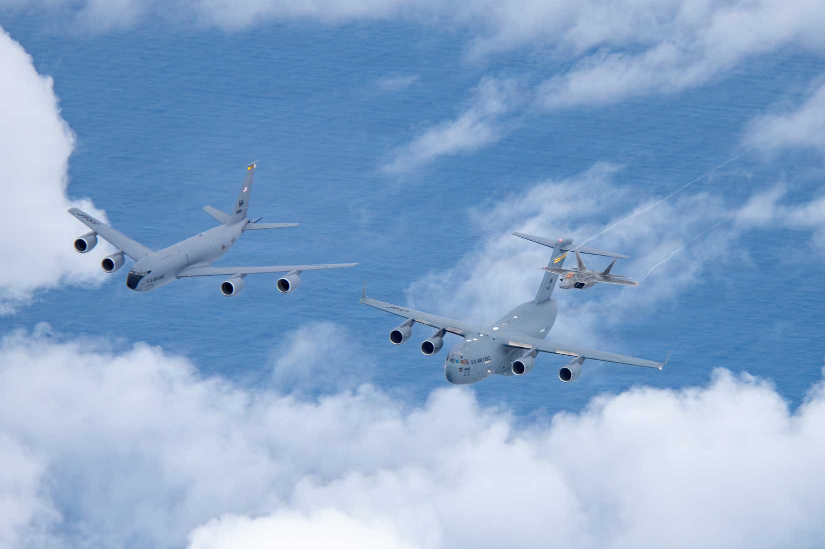 C-17 Globemaster III assigned to the 15th Wing, and a KC-135 Stratotanker and two F-22 Raptors assigned to the 154th Wing, demonstrating total force integration.