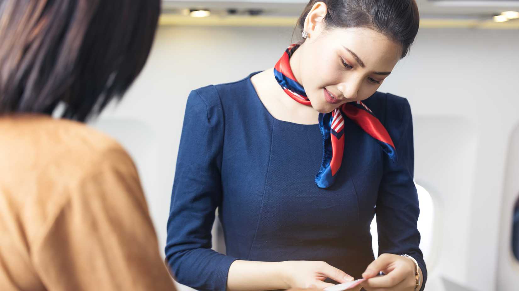 flight attendant checking a boarding pass