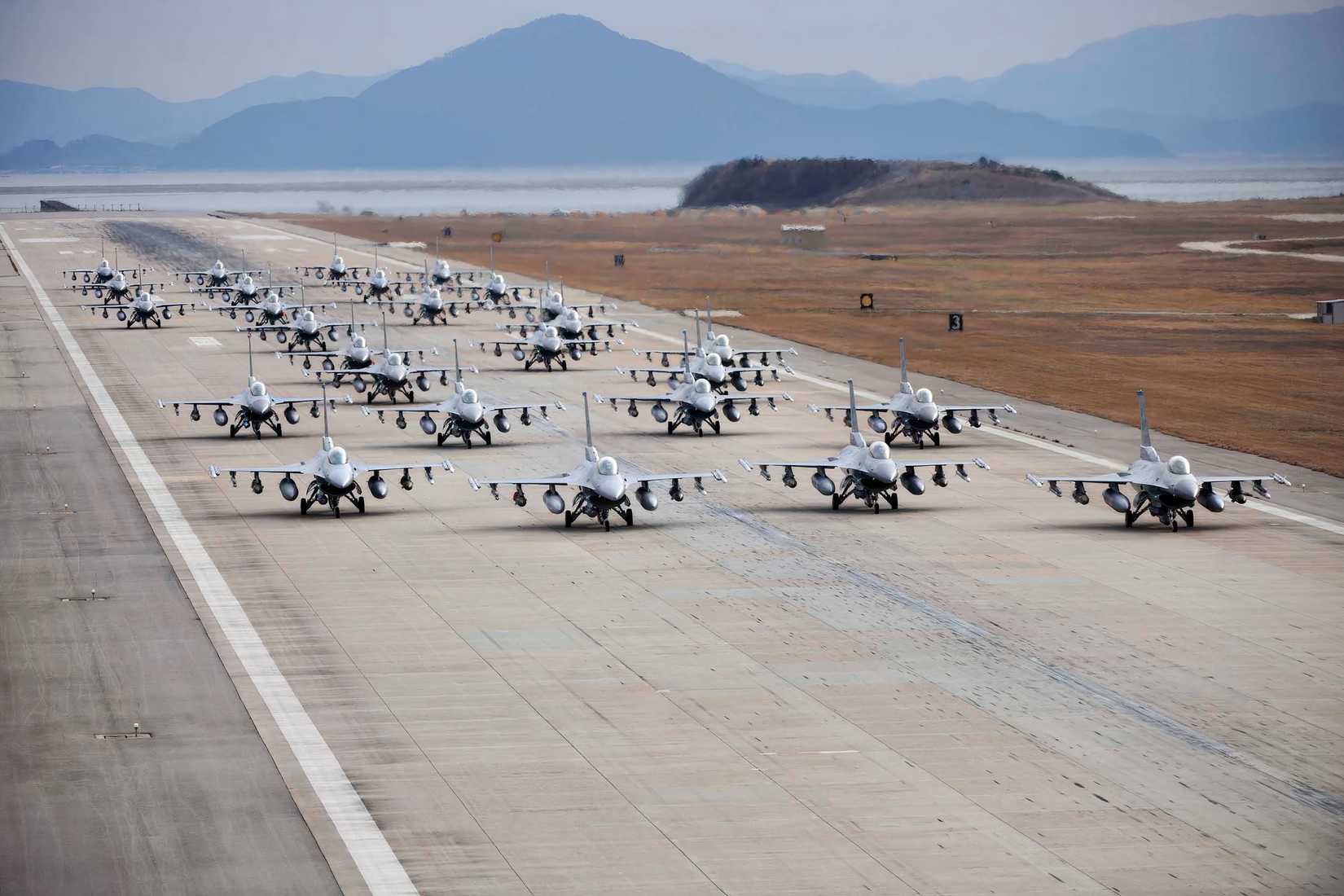 Numerous F-16's in formation on a runway for an "Elephant Walk"
