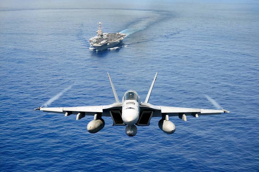 F-18 with an aircraft carrier in the background