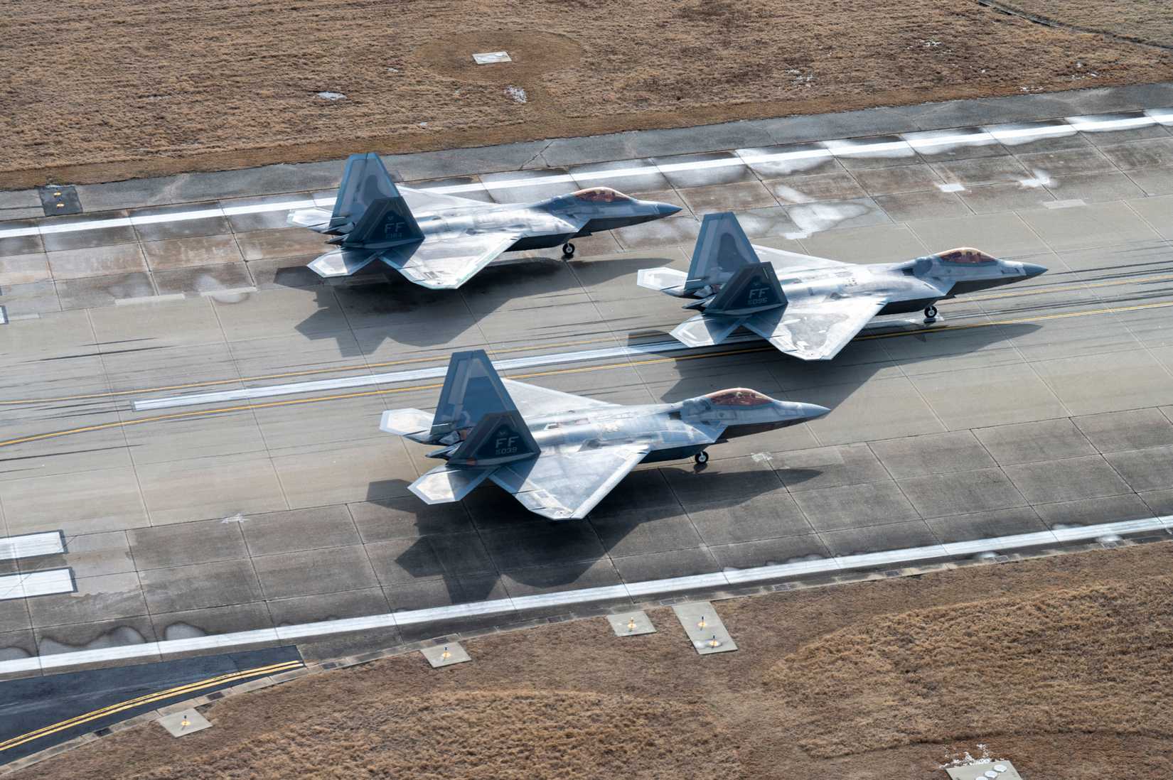 F-22 Raptors from the 1st Fighter Wing sit in position on the runway fduring the Elephant Walk at Langley Air Force Base, Virginia, Jan. 31, 2025.