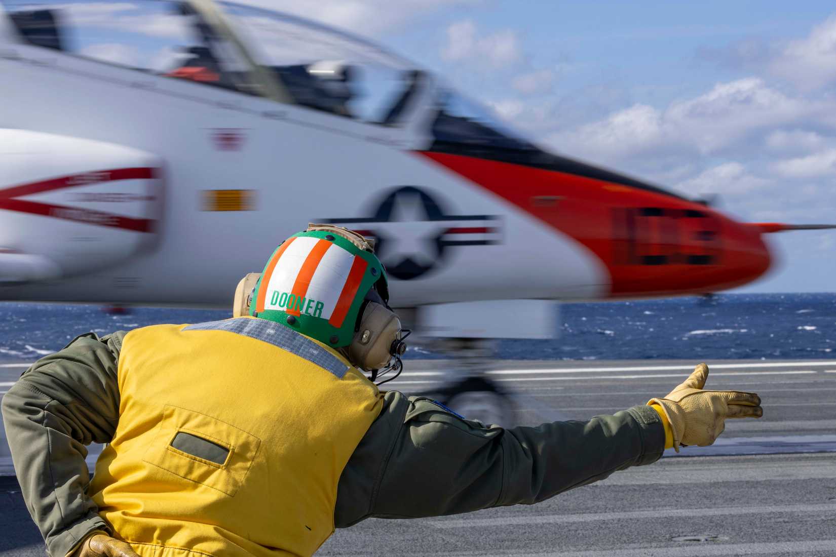 Lt. Danny “Dooner” Muldoon signals a T-45C Goshawk training aircraft attached to Training Air Wing (TW) 2 to launch off the flight deck aboard the Nimitz-class aircraft carrier USS George H.W. Bush (CVN 77).