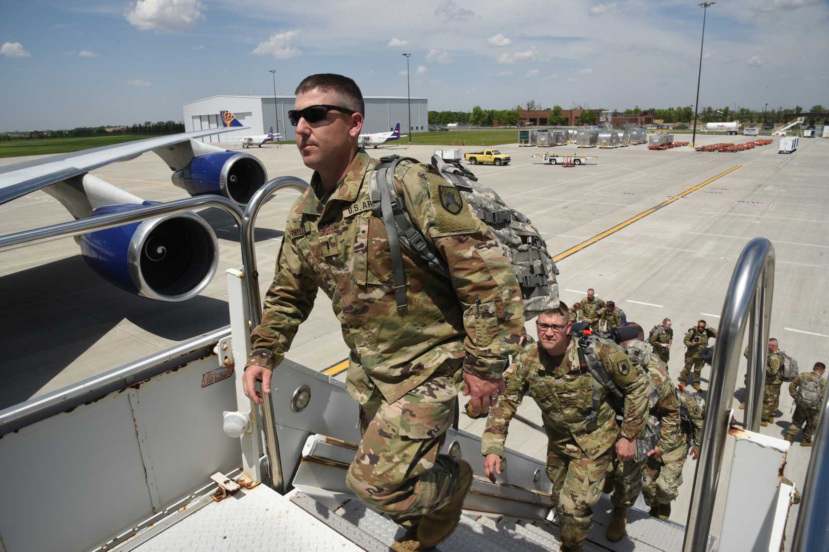 North Dakota Army National Guard, walks up stairs to a charter flight as he prepares to depart Hector International Airport, Fargo, N.D., June 7, 2019.