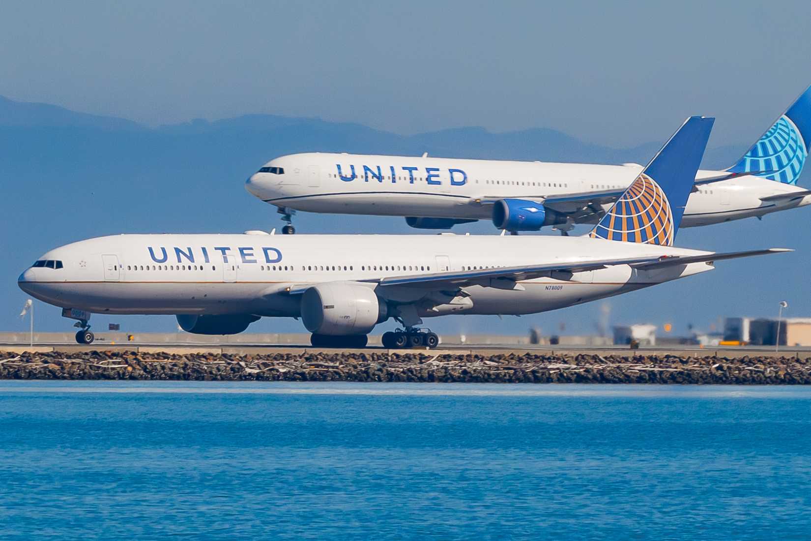November, 2025, A United Airlines aircraft lands at SFO while another taxis.