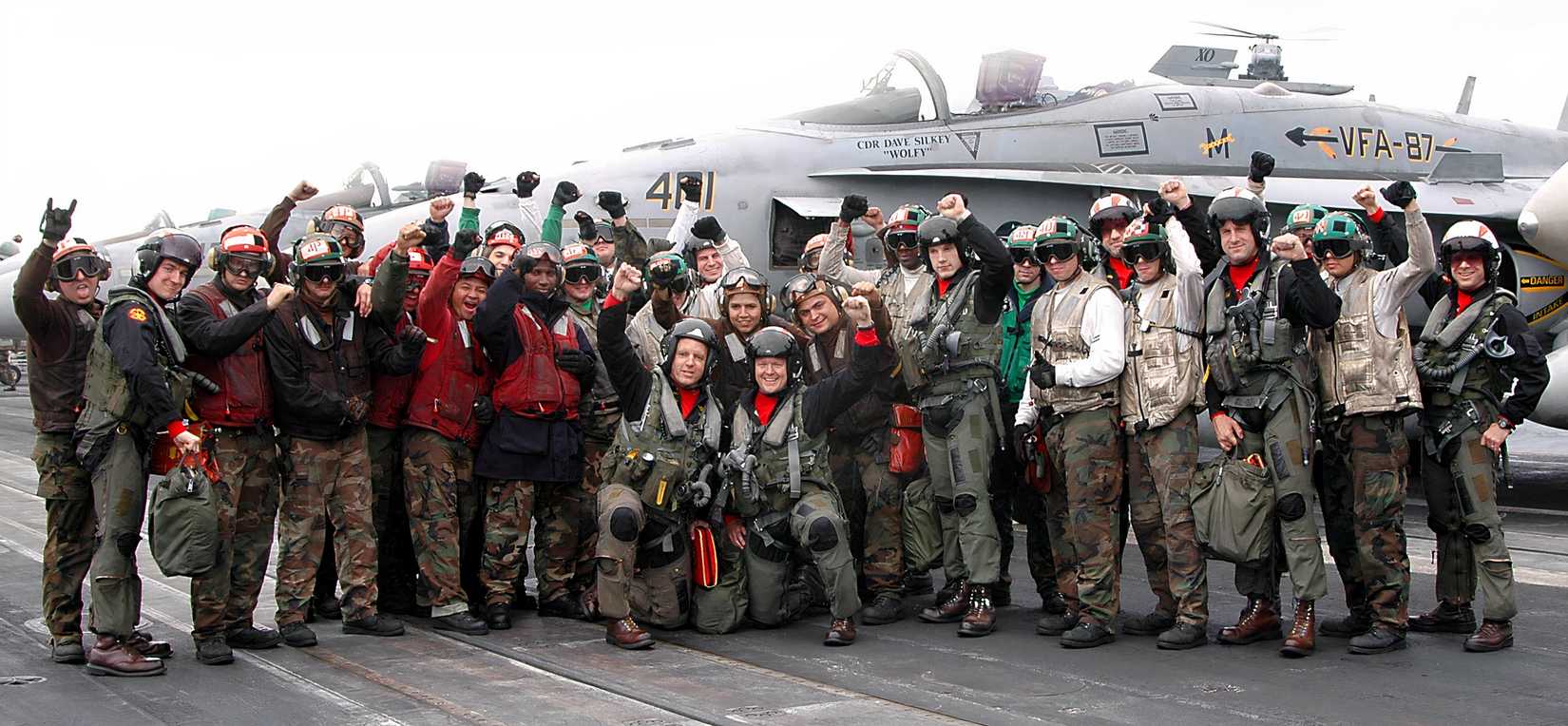 US Navy pilots with some crew aboard an aircraft carrier