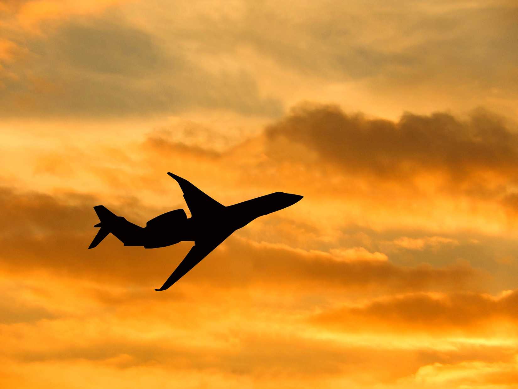 Private Jet Silhouette flying at sunset
