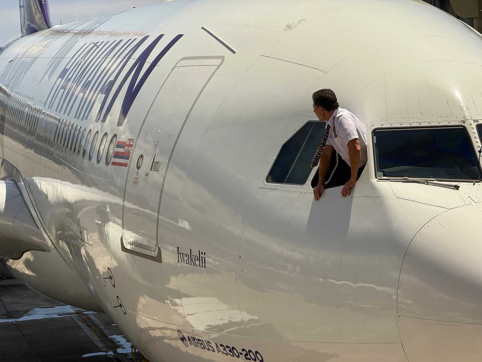 hawaiian airlines pilot leaning out of cockpit window