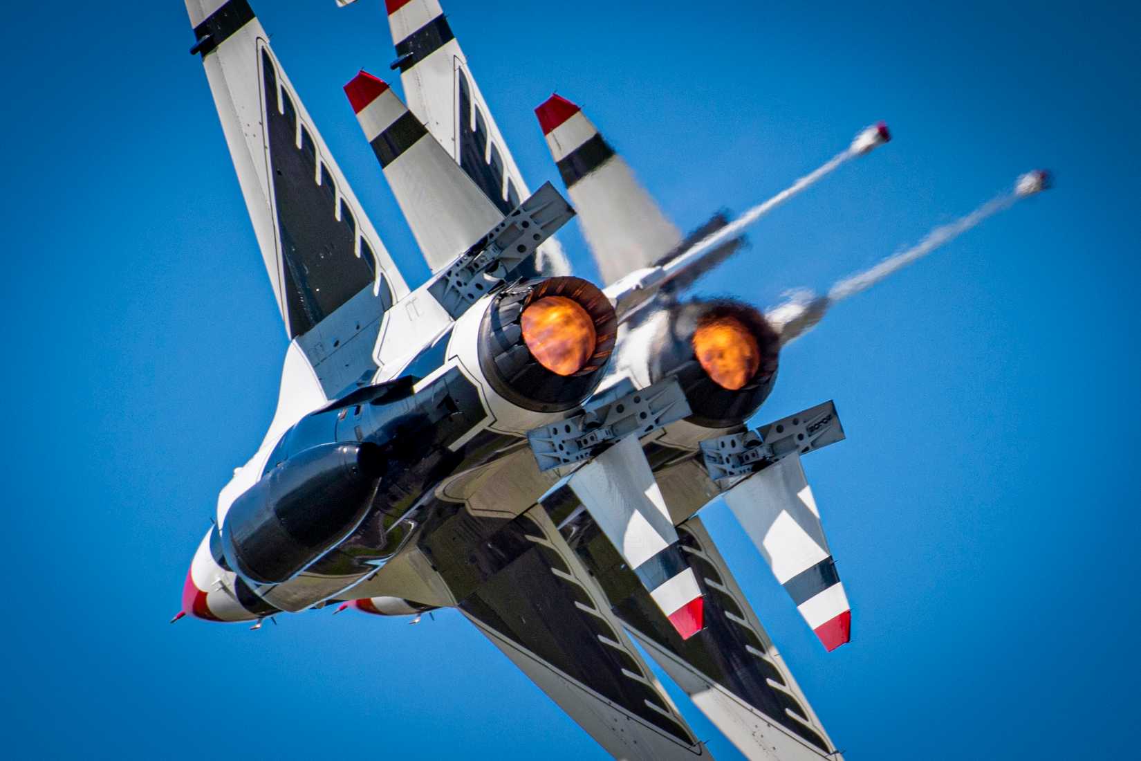 Two F-16 Thunderbirds perform the burner 360 during the Orlando Air and Space show.
